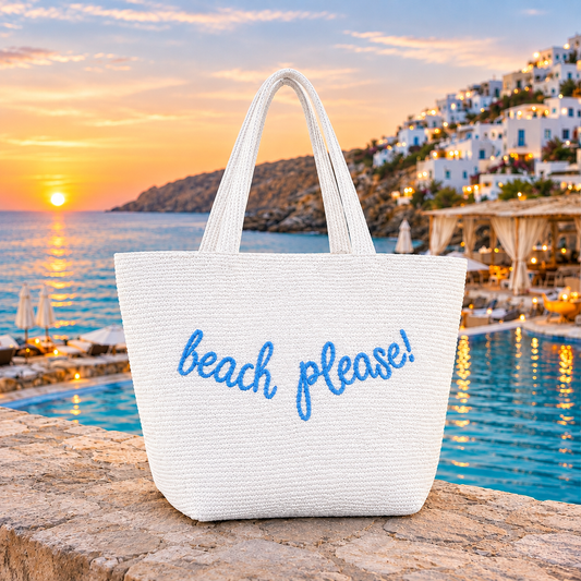 White woven beach tote bag with blue “beach please!” embroidered lettering and long handles