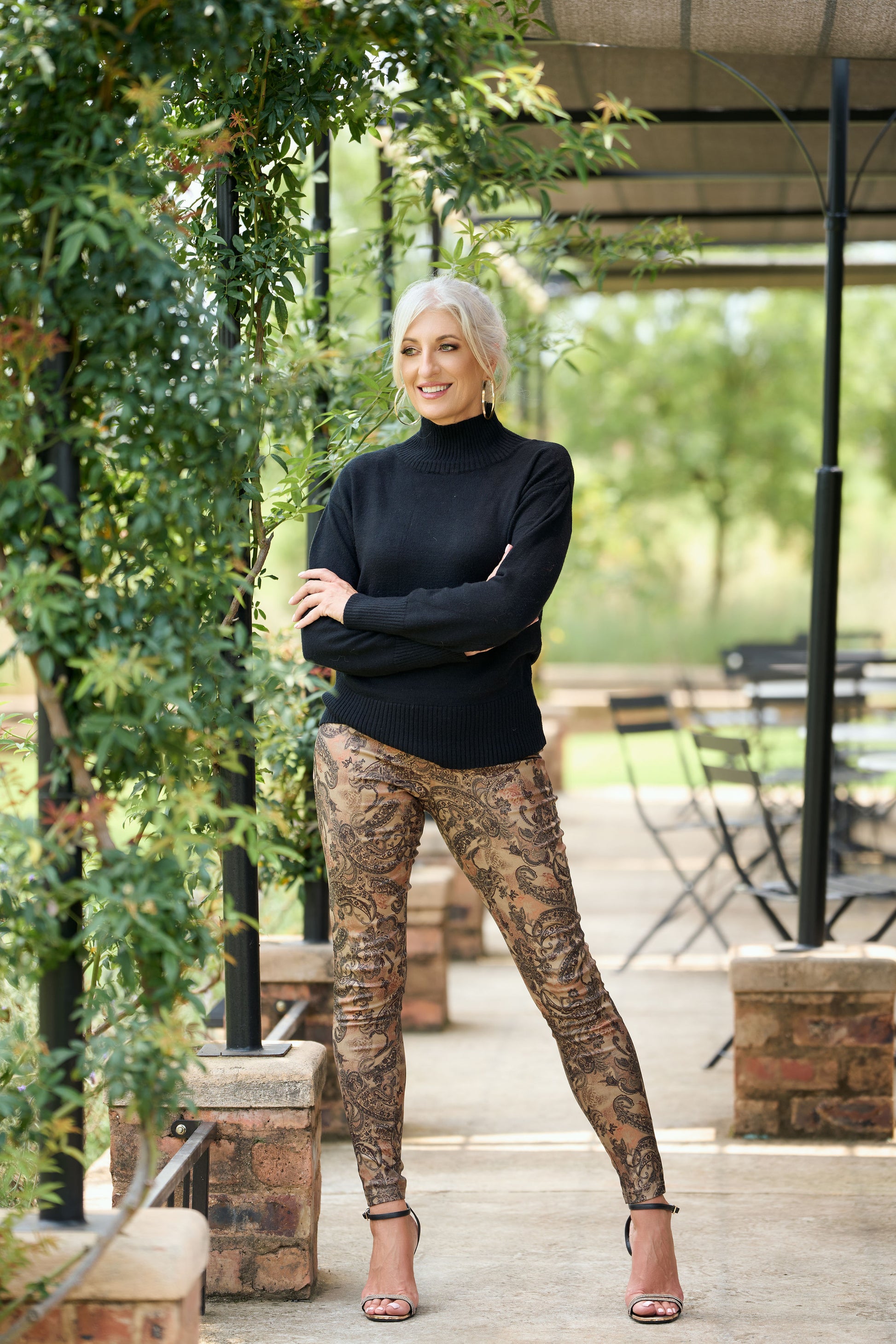Women's paisley print skinny pants in stretch fabric styled with black poloneck – boho chic fitted trousers for smart casual fashion.