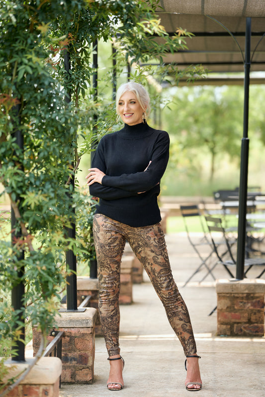 Women's paisley print skinny pants in stretch fabric styled with black poloneck – boho chic fitted trousers for smart casual fashion.