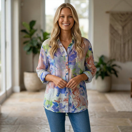 Colorful floral shirt on a hanger against a neutral wall with a plant to the left.
