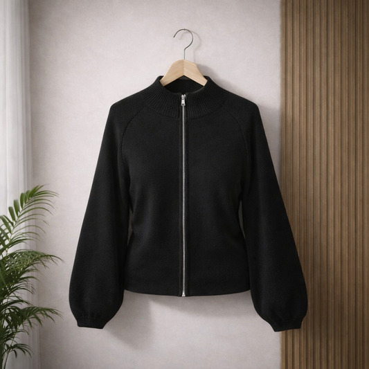 Black knitted zip-up jacket, showing ribbed collar, cuffs, and waistband with soft lighting.